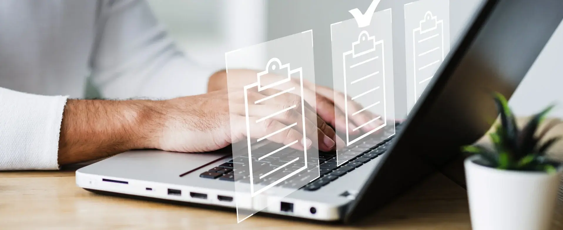 Hände, Laptop und Icons von Dokumenten